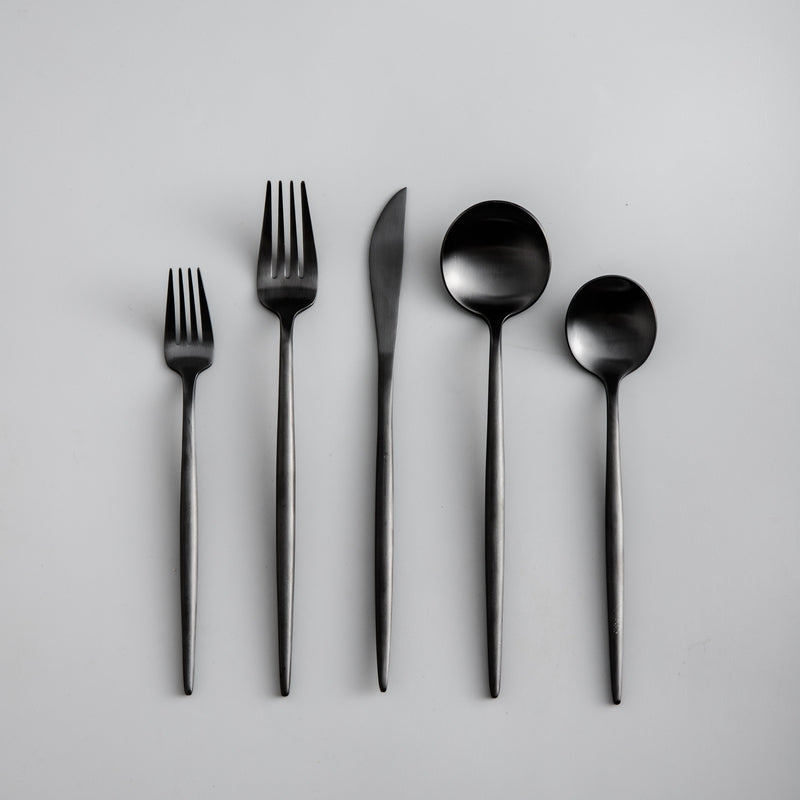 Full layout of a matte black cutlery set featuring minimalist modern design