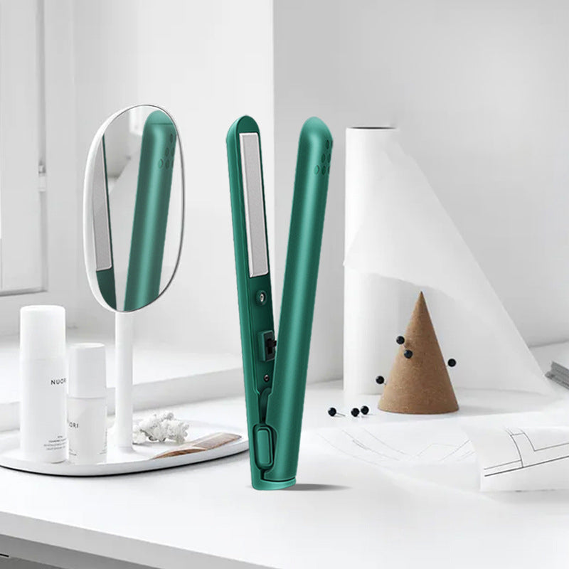 Open green mini hair straightener on a clean white vanity table next to cosmetic bottles