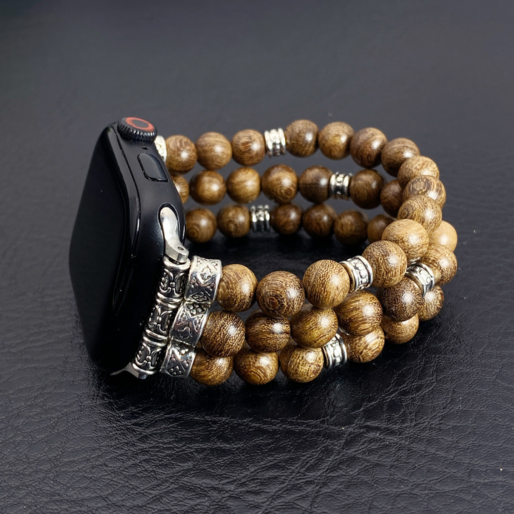 Close-up of beaded smartwatch band with metallic spacers on dark background