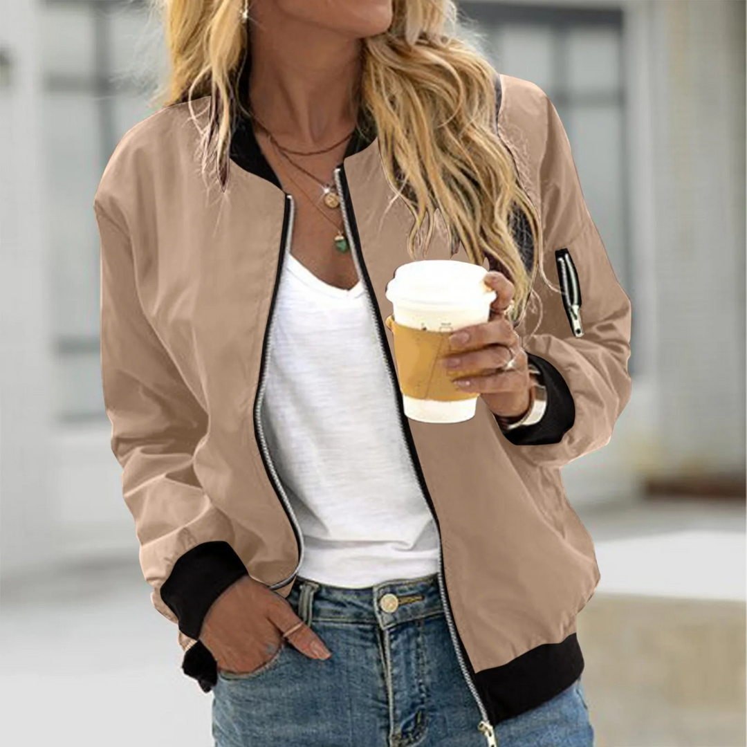 Woman wearing a beige everyday casual bomber jacket holding a coffee cup