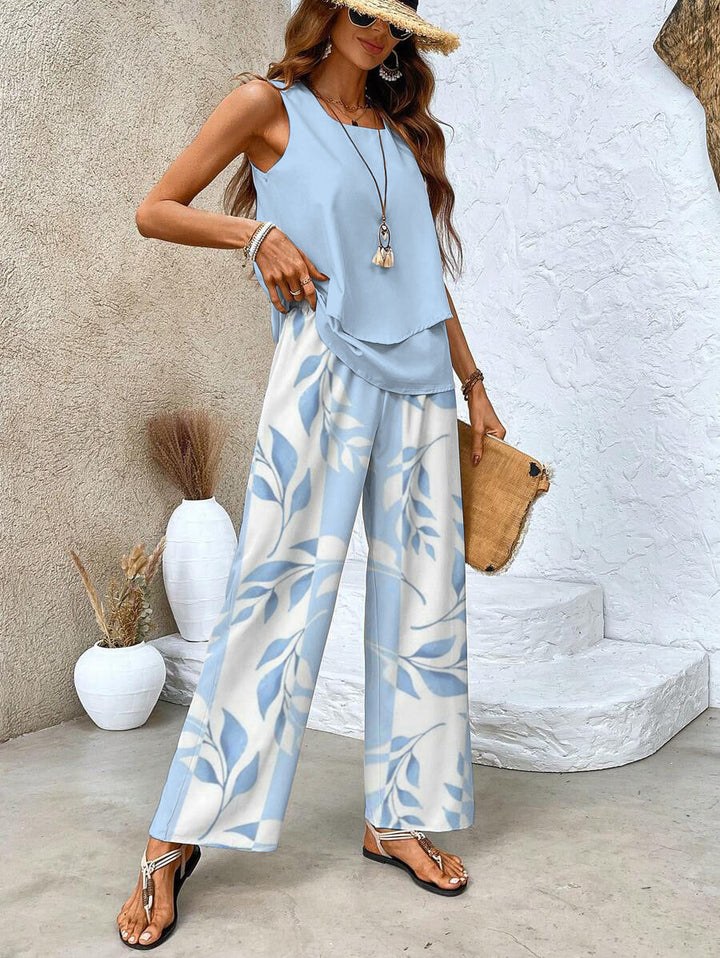 Close-up of a woman in a stylish light blue sleeveless layered top and patterned wide-leg pants
