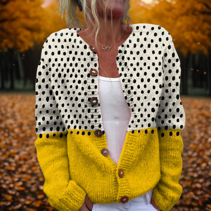 Close-up of the yellow polka dot knitted cardigan outdoors with autumn leaves