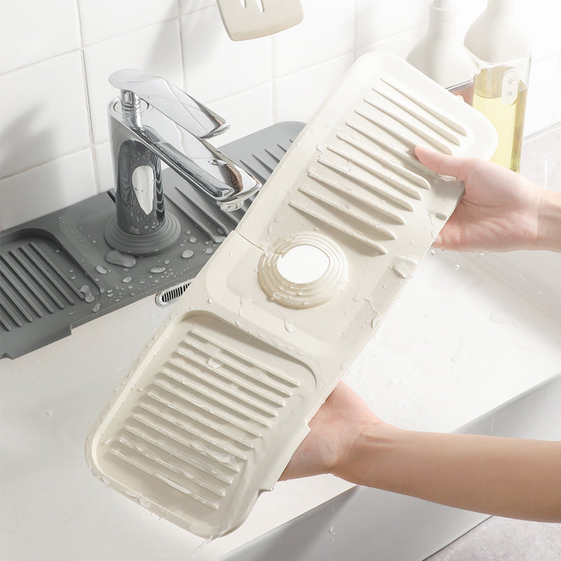 Close-up of a beige silicone dish drying mat near a modern kitchen faucet
