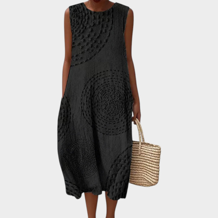 Woman wearing black sleeveless textured summer midi dress with woven bag