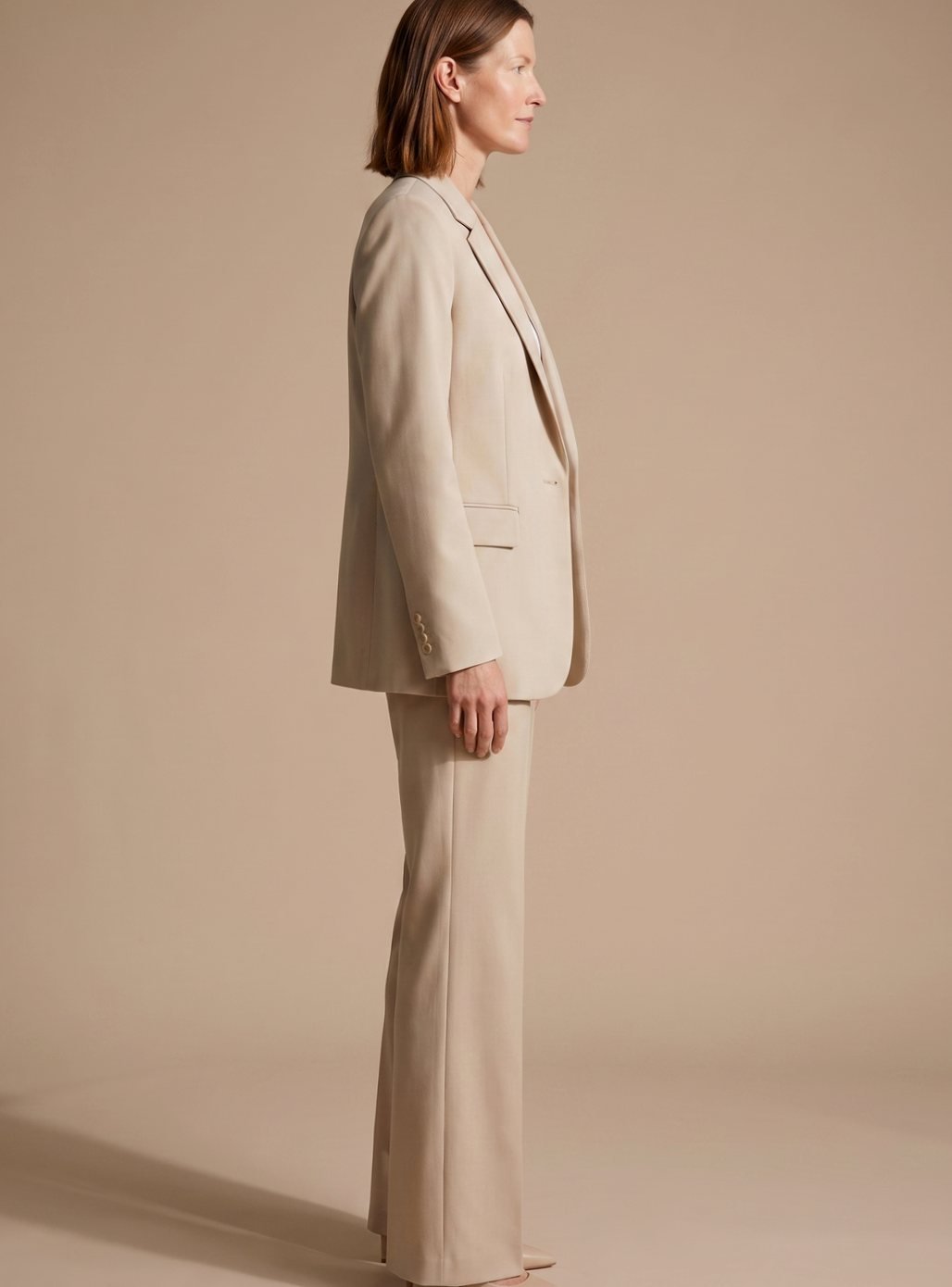 Side profile of woman wearing elegant beige blazer and flared pants