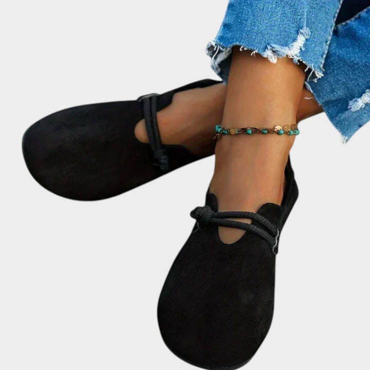 Close-up of black flat shoes showing flexible sole and soft material for women
