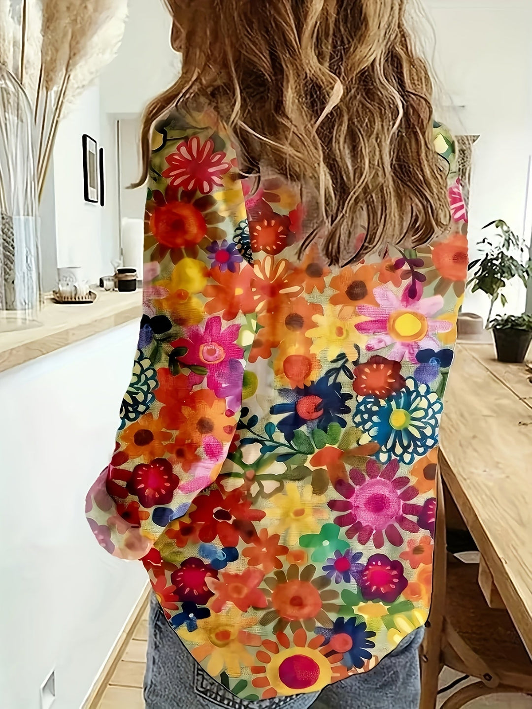 Back view of a woman wearing the colorful floral long sleeve shirt