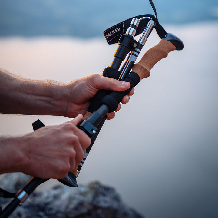 Compact foldable carbon poles packed inside a lightweight travel bag for backpacking convenience.