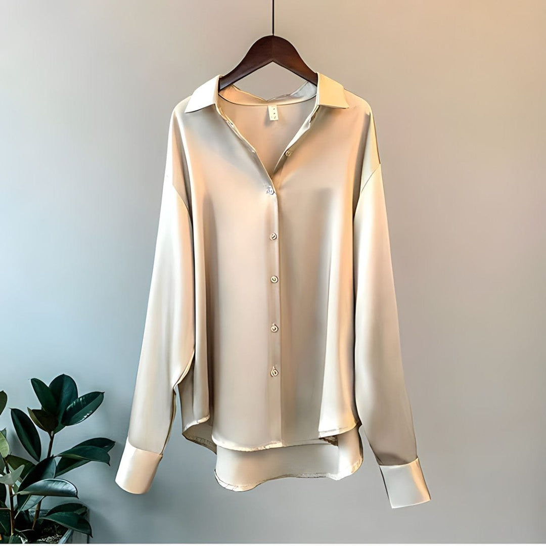 Champagne satin long-sleeve button-up blouse hanging on a hanger
