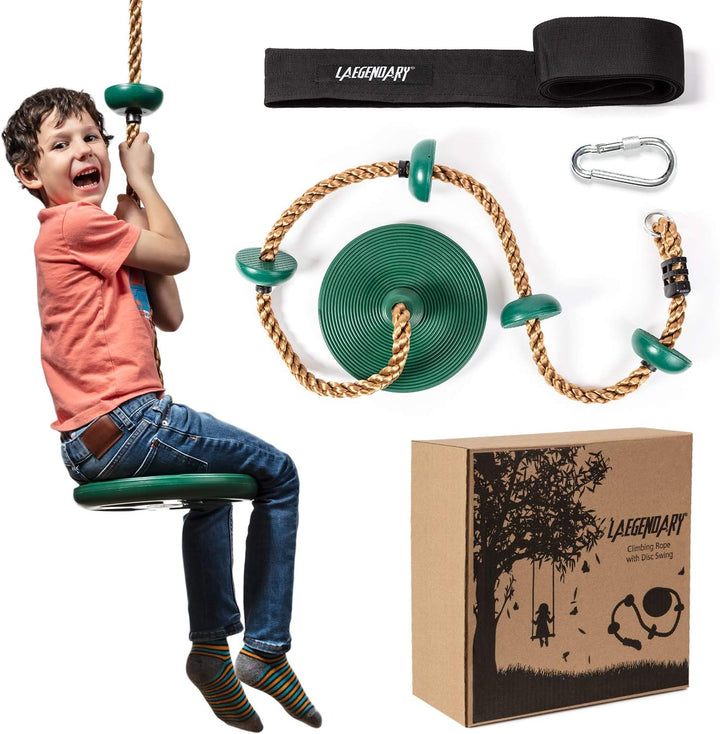 Boy smiling while sitting on a green disc tree swing outdoors