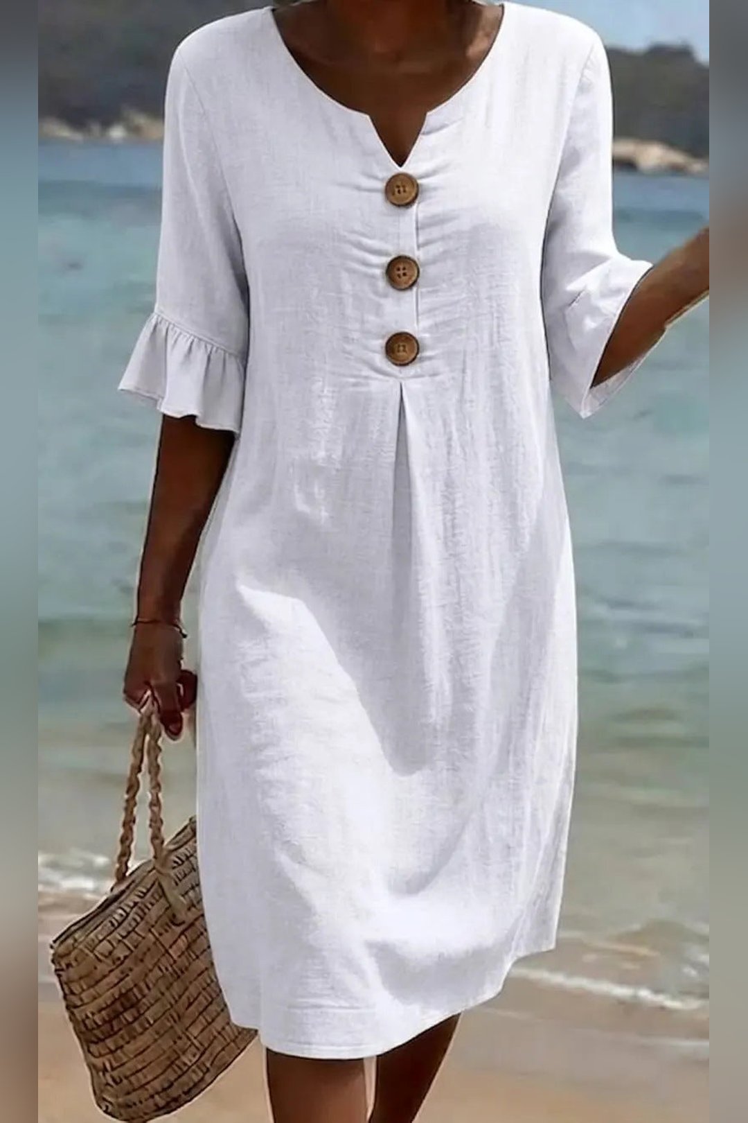 Woman wearing the white Mitzi casual button dress at the beach