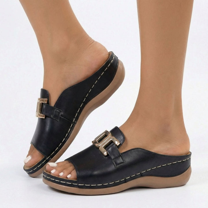 Side angle view of women's black wedge sandals showing comfortable heel height