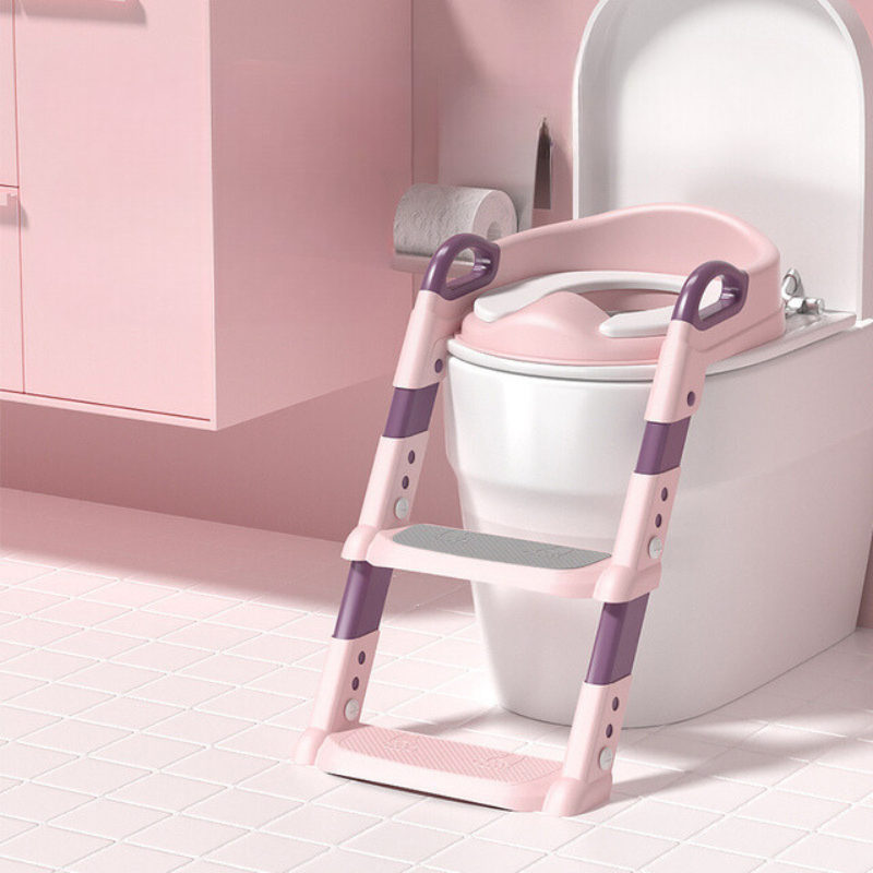 Pink toddler climbing potty training seat placed on a white toilet in a pink-themed bathroom