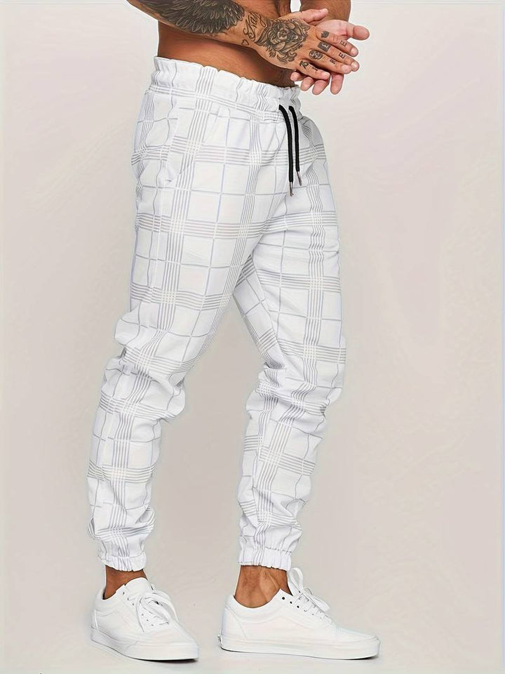 Side profile of men's sporty trousers showing deep side pockets and elastic ankle cuffs.