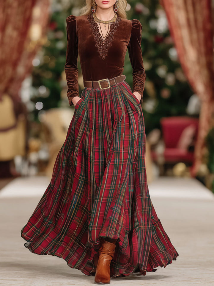 Front view of a woman wearing a brown V-neck long sleeve top and a red plaid midi skirt with a belt.