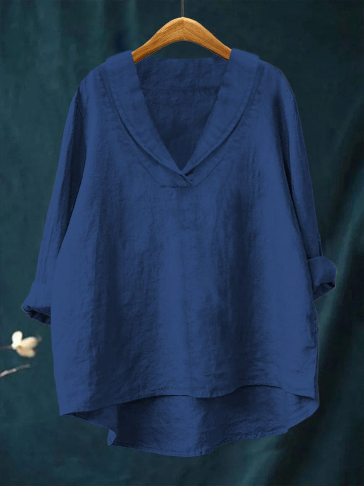 Blue women's timeless blouse hanging on wooden hanger
