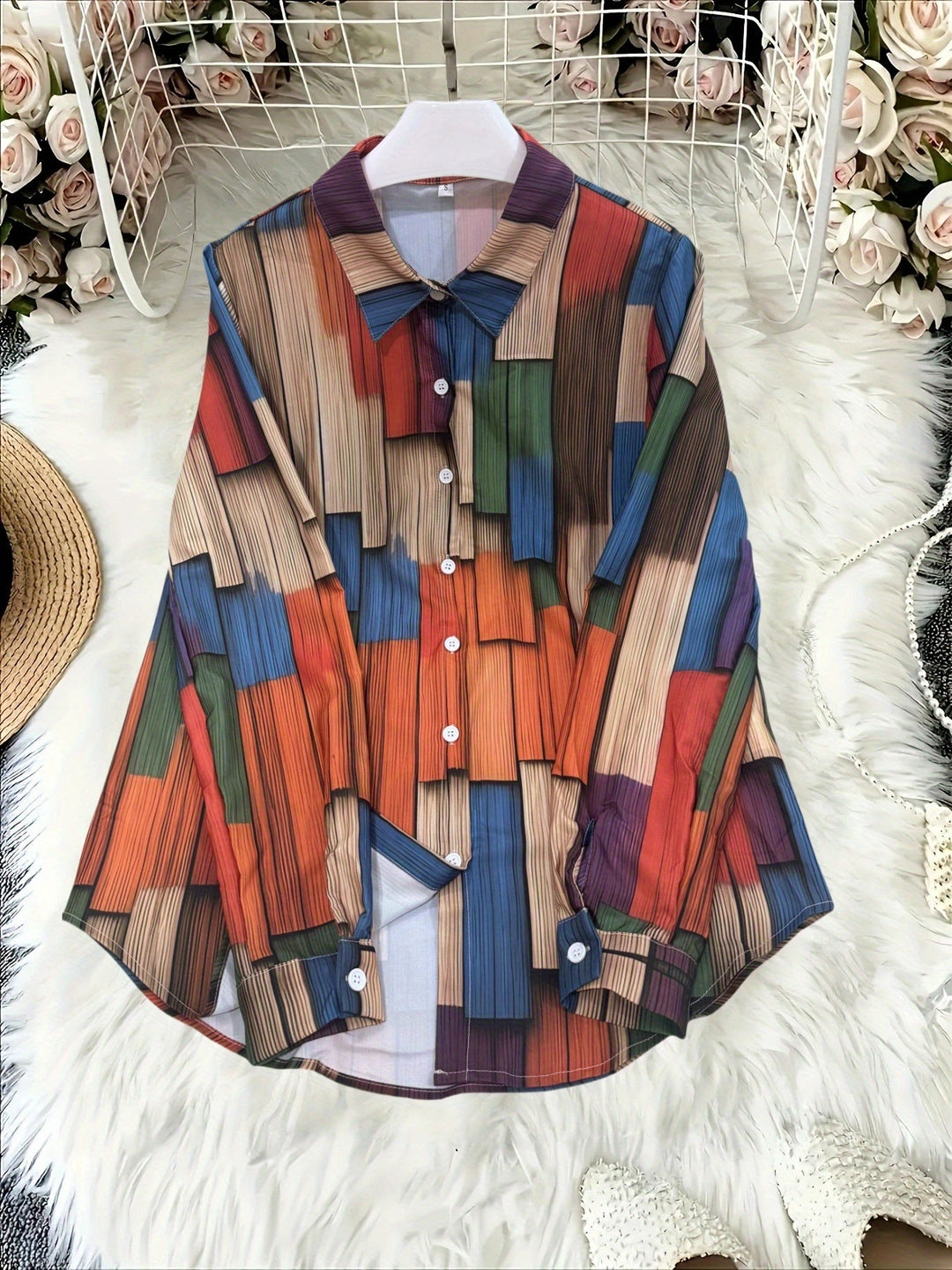 Front view of the button-up geometric print blouse laid flat