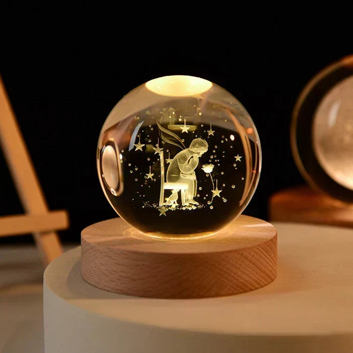 Illuminated 3D crystal ball night light featuring a sitting figure on a wooden base