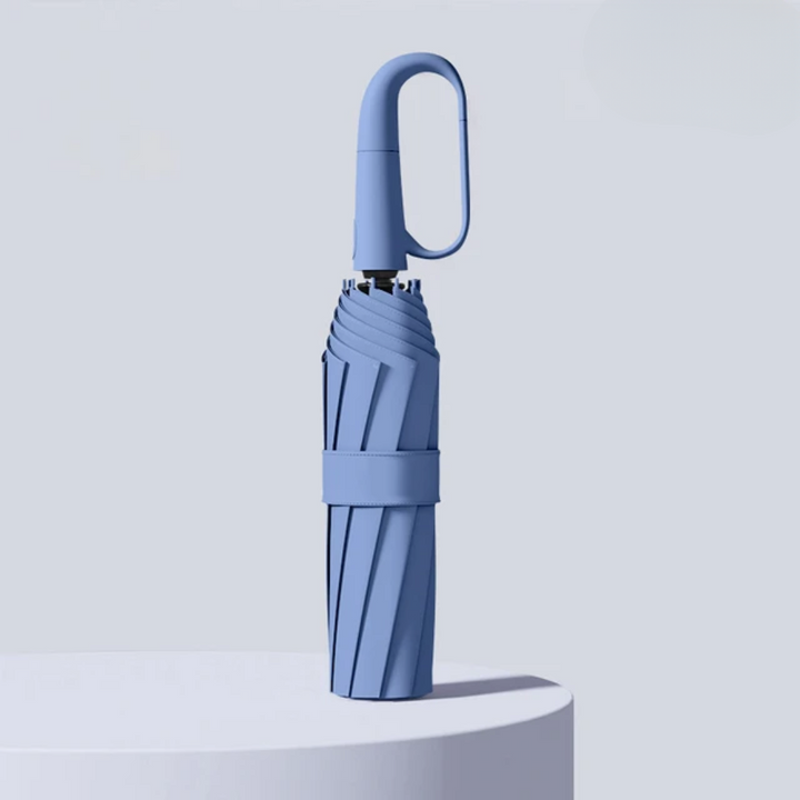 Compact blue automatic windproof umbrella standing upright on a podium