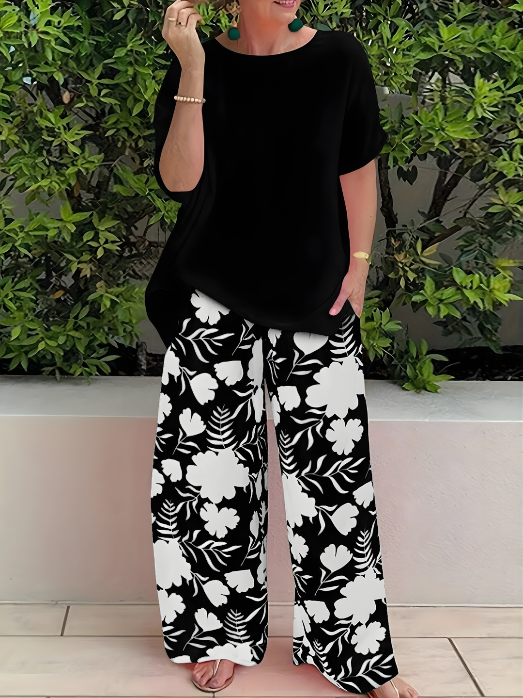 Woman wearing a black casual top and coordinating floral trousers