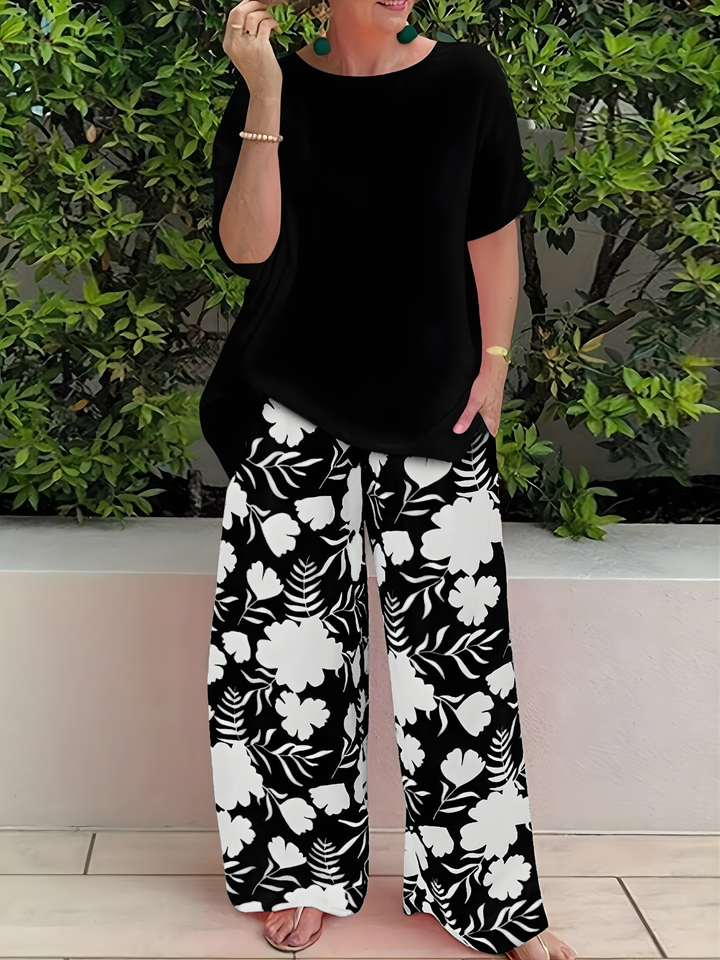 Woman wearing a black casual top and coordinating floral trousers