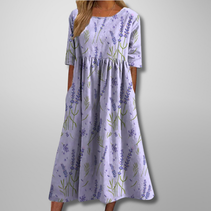 Model wearing light purple short-sleeve floral midi dress with botanical pattern