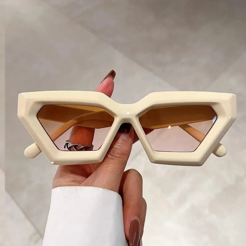 Beige vintage cat-eye sunglasses held up showing gradient lenses