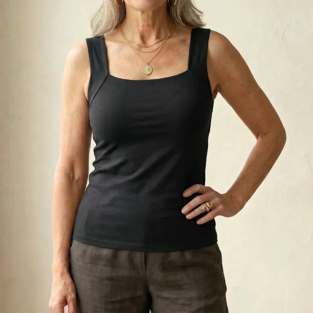 Woman wearing a black tank top with built-in bra paired with trousers