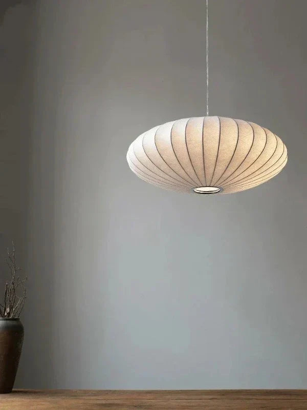 Illuminated silk pendant lamp showcasing its warm glow and crystal accents