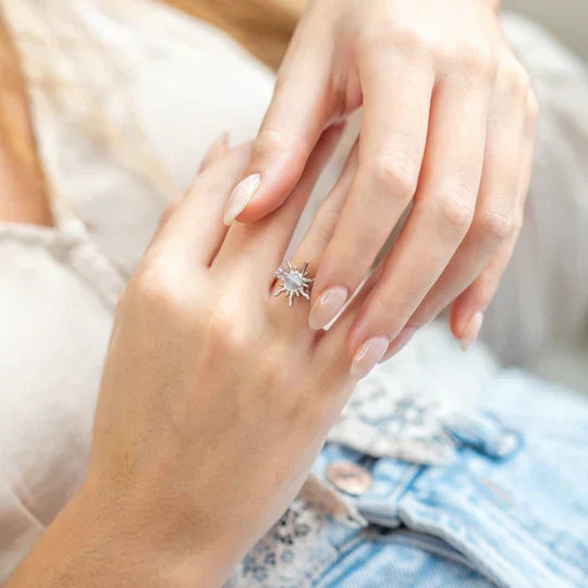 Woman wearing a delicate silver sun fidget ring on her finger with a casual outfit