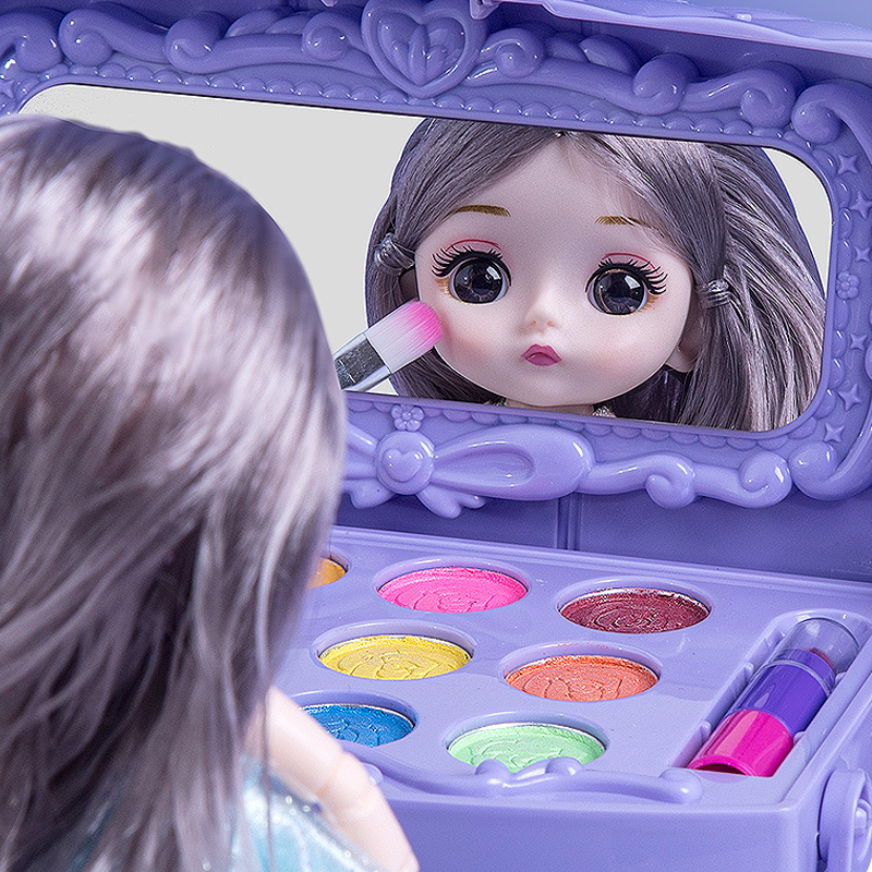 Close-up of a doll looking into the vanity case mirror while applying eyeshadow