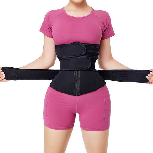 Woman wearing black slimming waist trainer belt with pink workout clothing