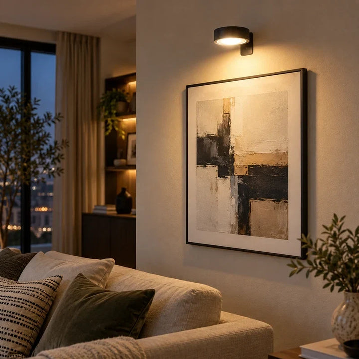 Rechargeable picture light glowing softly in a dimly lit hallway above a framed poster