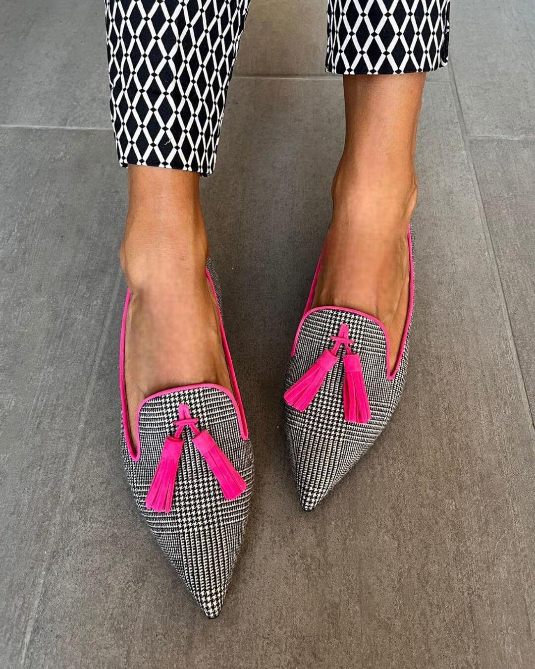 Close-up of fringe and pointed toe design on pink loafers
