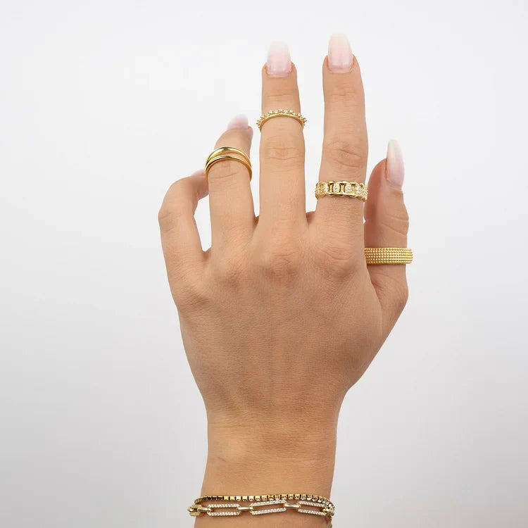 Hand wearing gold Aluna double band ring and matching stackable rings