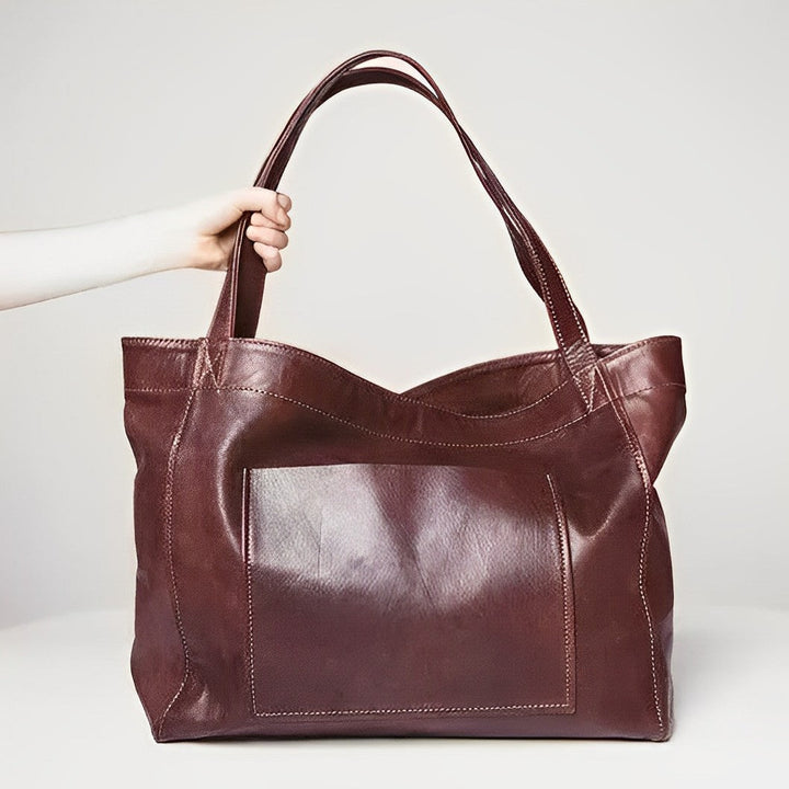 Wine colored vintage shoulder bag shown against a neutral studio backdrop