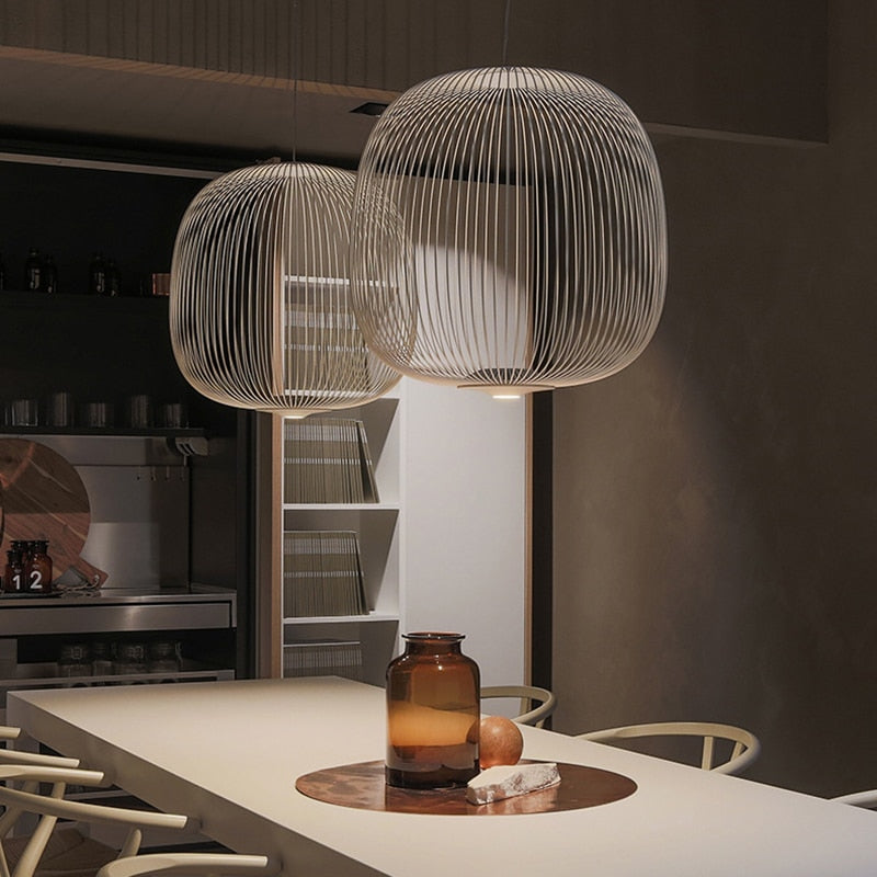 Two white architectural iron pendant lights hanging above a modern dining table