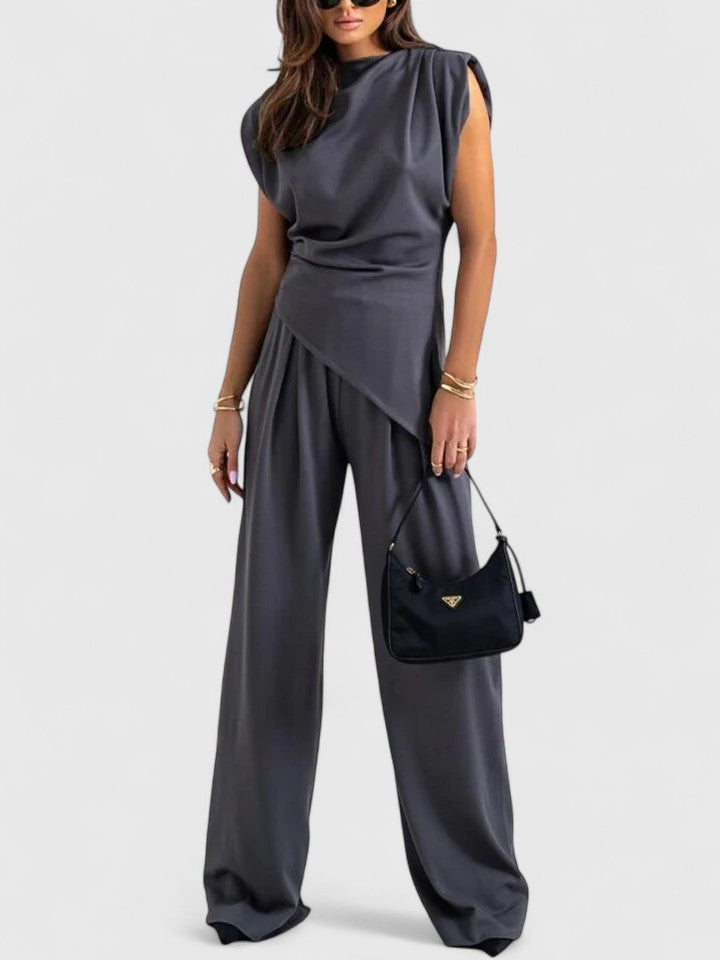 Woman wearing dark grey asymmetric top and matching wide leg trousers
