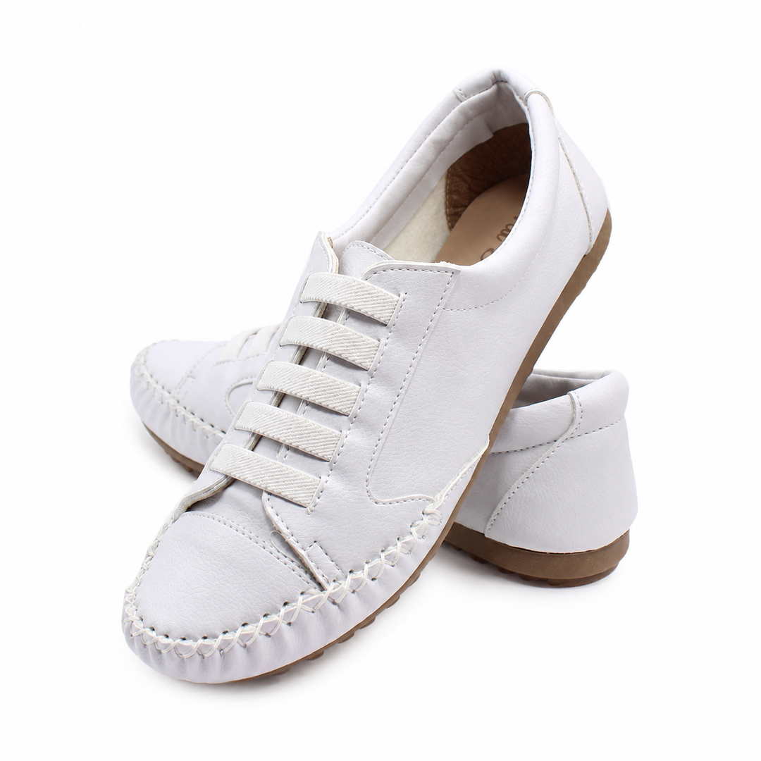 Close-up of a white slip-on loafer sneaker with elastic closure and decorative stitching
