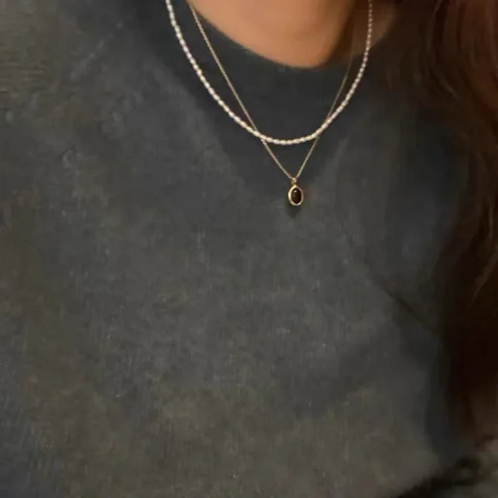 Model wearing the stacking necklace set, highlighting the fashionable layered pearl design.