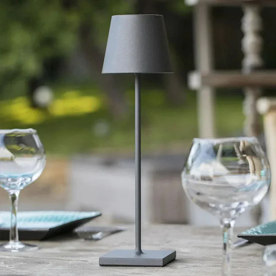 Matte Grey portable touch table lamp illuminating an outdoor patio setting