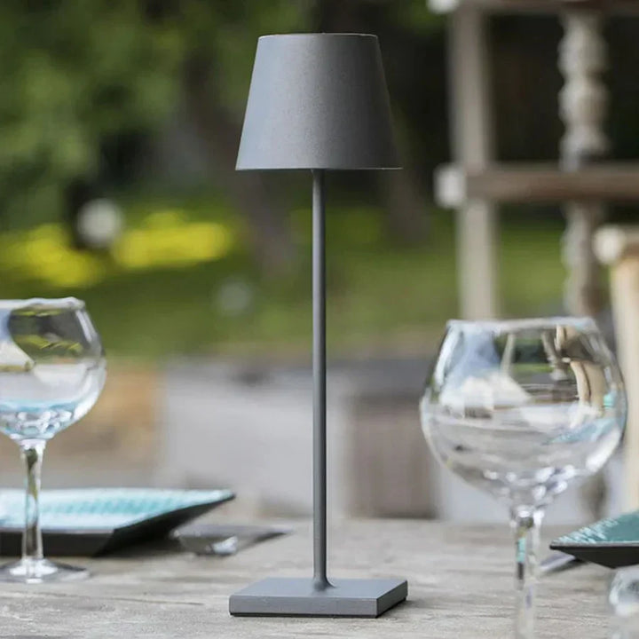 Matte Grey portable touch table lamp illuminating an outdoor patio setting