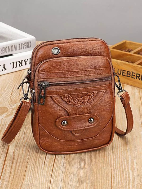 Brown vintage crossbody bag front view on wooden table
