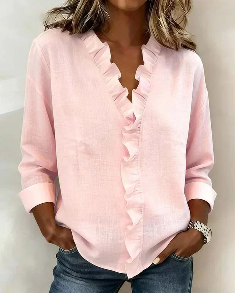 Woman wearing pink lightweight V-neck ruffled blouse