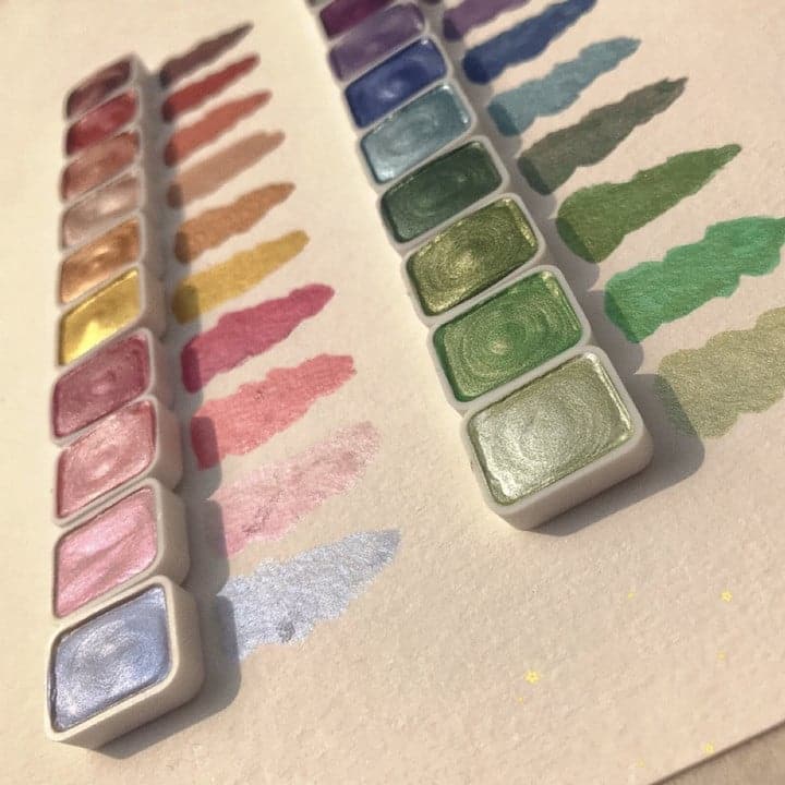 Close-up view of shimmering watercolour pans and brush strokes