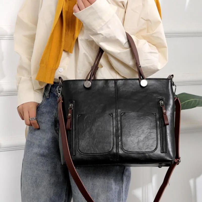 Black multi-pocket handbag for women displayed with a detachable crossbody strap