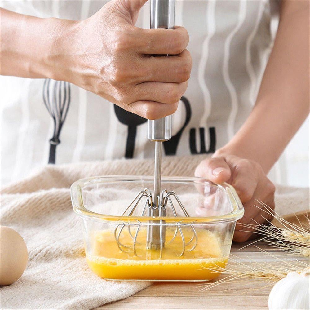 Kitchen gadget whisk mixing batter in a glass bowl