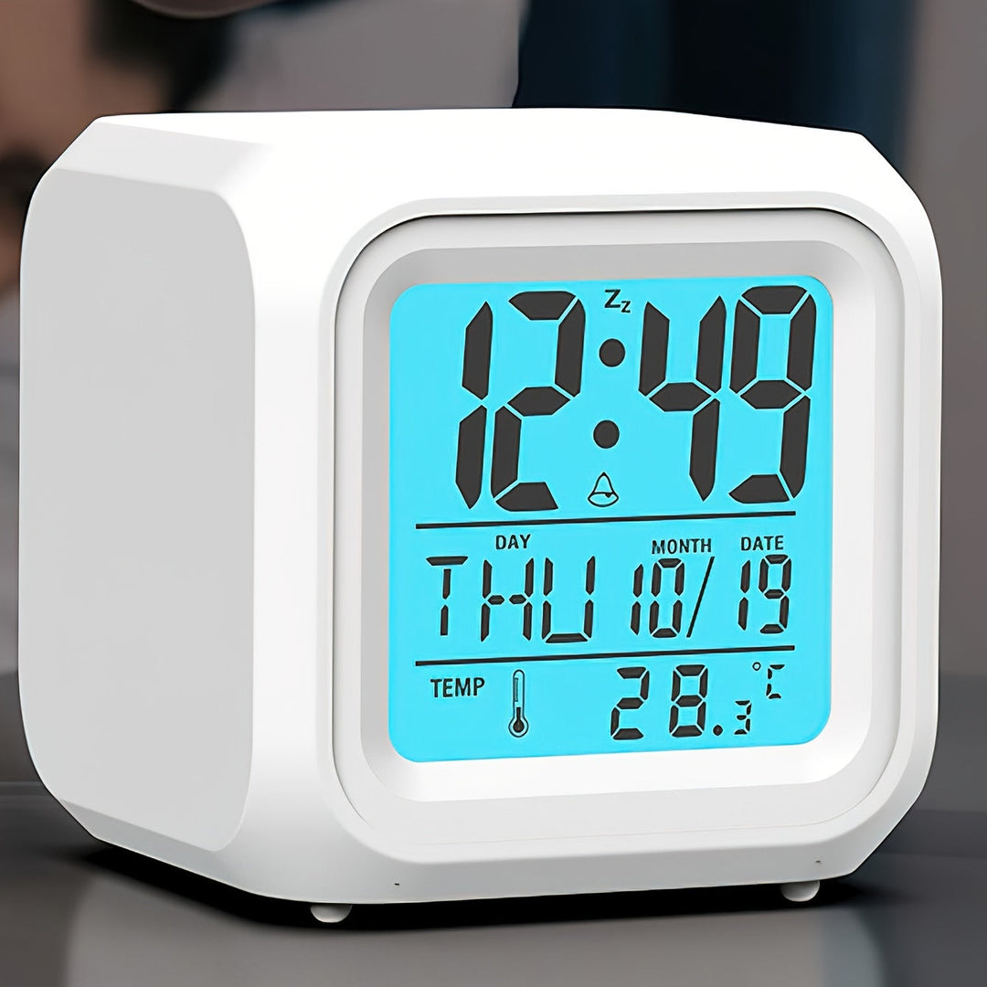 Modern white digital LED alarm clock displaying time, day, date, and temperature on a glowing blue screen