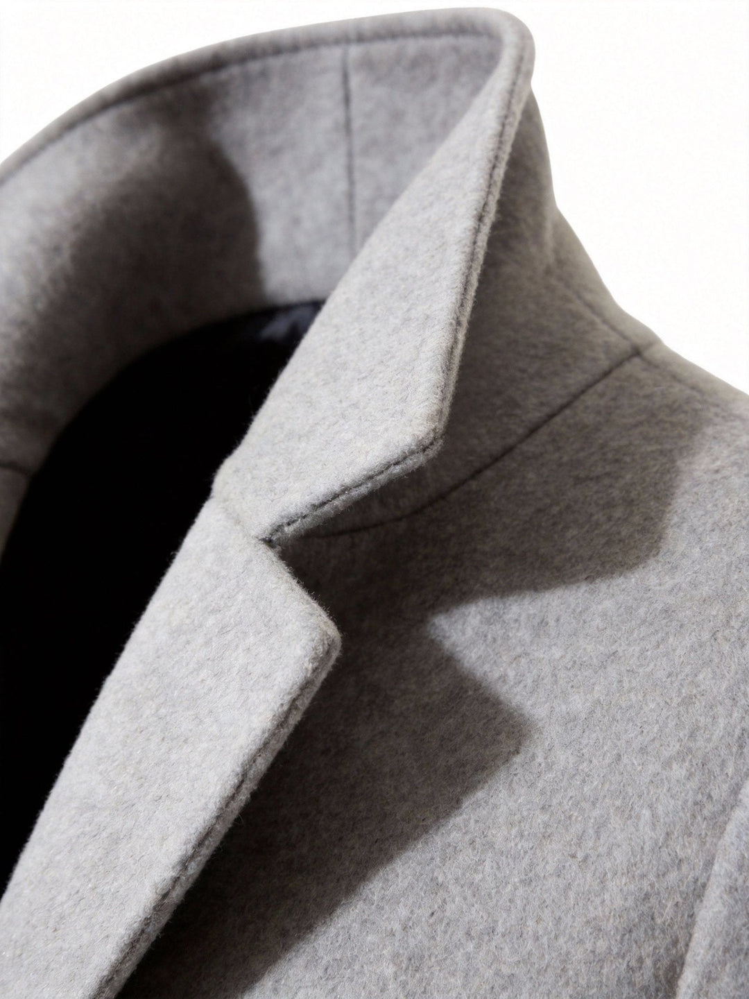 Men's trench coat folded neatly to showcase packability and travel-friendly fabric.