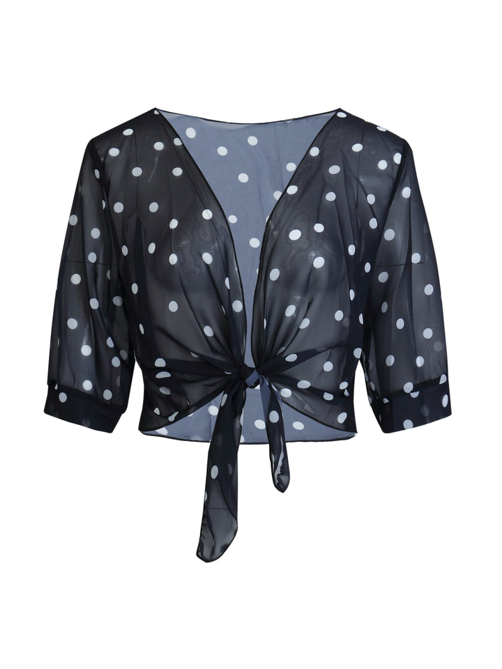 Detailed shot of the V-neckline and functional tie-front knot on a casual polka dot blouse